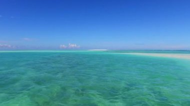 Sahil kenarındaki beyaz kumlu arka planda şeffaf deniz kenarında mükemmel bir turist plajı tatili.