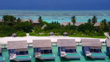 Güneşin doğuşundan sonra sakin sahil manzarası berrak su ve temiz kumlu zemin ile kesiliyor.