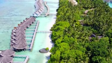 Mavi okyanus ve kumsalın yakınındaki beyaz kumlu arka planda geniş açılı sahil macerası.