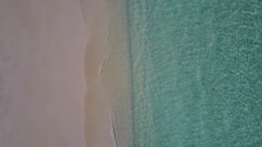 Parlak kumlu arka planlı, mavi okyanus kıyısında lüks deniz kıyısı gezisinin insansız hava aracı.