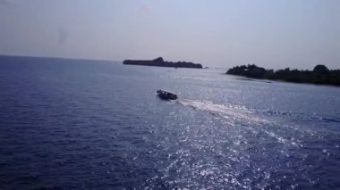 Tropikal körfez sahil yaban hayatının deniz mavisi okyanusu ve dalgaların yakınındaki temiz kum arka planının ılık yolculuğu.