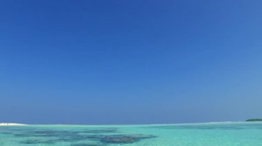 Mavi okyanus kıyısındaki mükemmel sahil turizmi ve tatil beldesi yakınlarındaki beyaz kumlu arka plan.