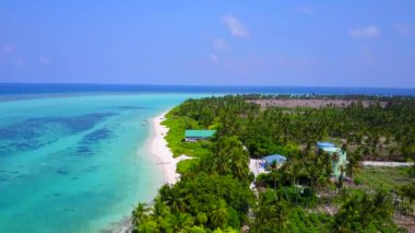 Mavi okyanus ve beyaz kum arka planında huzurlu sahil yaşam tarzının hava yolculuğu