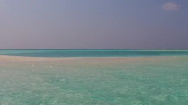 Temiz göl kenarındaki güzel sahil yolculuğunun güneşli manzarası ve kumsal kenarındaki beyaz kum arka planı.