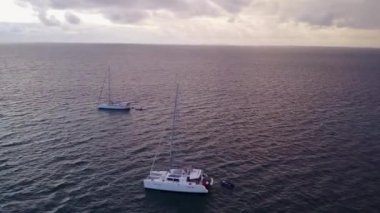 Deniz kıyısında güneşli bir yolculuk. Su mavisi deniz kıyısında, tatil köyü yakınlarında beyaz kumlu bir arka plan.