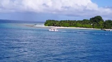 Deniz tatil köyünün romantik soyut sahili gün batımından önce sığ deniz ve beyaz kumlu zemin tarafından kırılıyor.