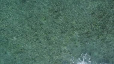 Deniz lagününün güneşli manzarası. Deniz mavisi gölün kenarında. Beyaz kumlu arka planda güneş ışığı var.