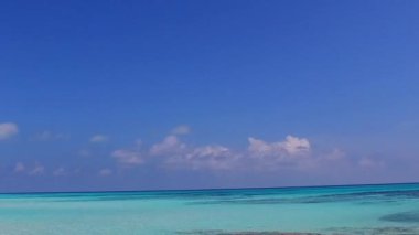 Temiz lagün ve kumsalın yakınındaki beyaz kumlu arka planda sakin lagün plaj yolculuğunun boş manzarası