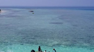 Cennet Körfezi sahili macerasının boş manzarası. Mavi deniz ve resifin yanındaki beyaz kumlu zemin.