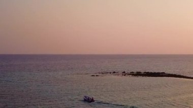 Mavi deniz ve beyaz kum arka planındaki huzurlu sahil yolculuğunun insansız hava aracı doğası.
