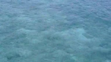 Mavi sular ve dalgaların yakınındaki beyaz kumlu arka planda, cennet gibi göl gezilerinin romantik manzarası