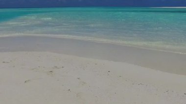 Gün batımından önce beyaz kum arka planlı sığ deniz kıyısında cennet manzarası.