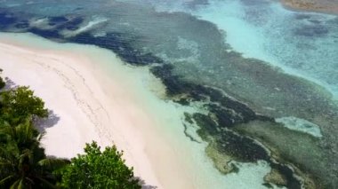 Turkuaz deniz ve güneş doğduktan sonra beyaz kumlu arka planda güzel bir tatil köyü manzarası.