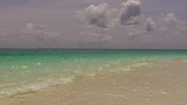 Deniz tatil beldesi sahil macerasının boş yolculuğu. Su mavisi bir göl ve tatil köyü yakınlarındaki parlak kum örtüsü.