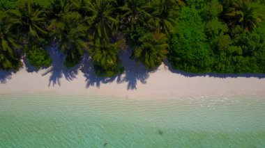 Turkuaz su ile egzotik deniz manzarası ve tatil köyü yakınlarındaki beyaz kum manzarası.