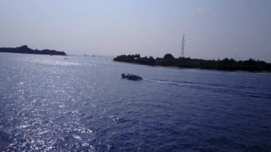 Mavi okyanus kıyısındaki tropik tatil köyü sahil yaşam tarzının güneşli dokusu ve kumsalın yakınındaki beyaz kum arka planı.