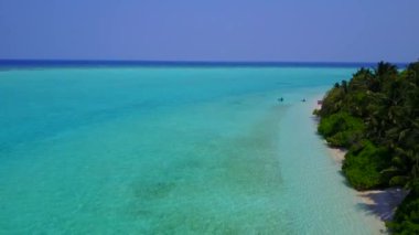 Temiz kum arka planına sahip mavi okyanus kıyısındaki güzel sahil yaşam tarzının insansız hava aracı yolculuğu
