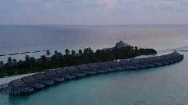 Parlak kumlu arka planda şeffaf deniz kenarında rahatlatıcı lagün plaj macerasının insansız hava manzarası