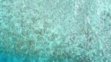 Kumsalın yakınındaki kumlu beyaz arka planda, mavi sularda güneşli bir tatil köyü soyutlaması.