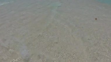 Turkuaz suların oluşturduğu egzotik lagünün güneşli deniz manzarası. Resifin yakınındaki beyaz kumlu arka plan.