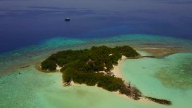 Turkuaz okyanus ve kumsalın yakınındaki beyaz kumlu arka plan ile lüks turistik plaj gezisi manzarasını kapatın.