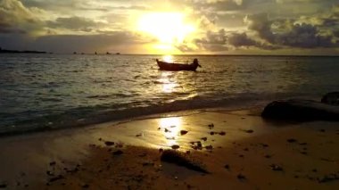 Güneş ışığında temiz kumlu arka plana sahip sığ okyanus tarafından sakin bir göl manzarası.