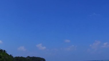 Mavi yeşil su ve dalgaların yakınındaki beyaz kumlu arka planla cennet gibi sahil yaşam tarzını kopyala