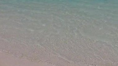 Mavi okyanus kıyısındaki güzel sahil manzarası ve sörf yapmaya yakın beyaz kum arka planı.