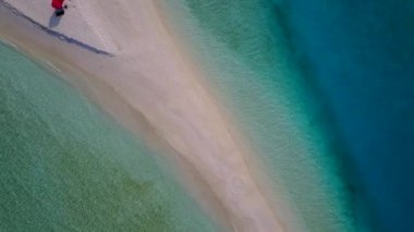Sığ okyanus ve dalgaların yakınındaki beyaz kumlu arka planda egzotik lagünün yaz seyahati