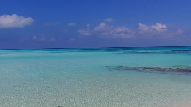 Słoneczna panorama morskiego kurortu czas plaży nad błękitną wodą z jasnym piaskiem tło w słońcu — Wideo stockowe