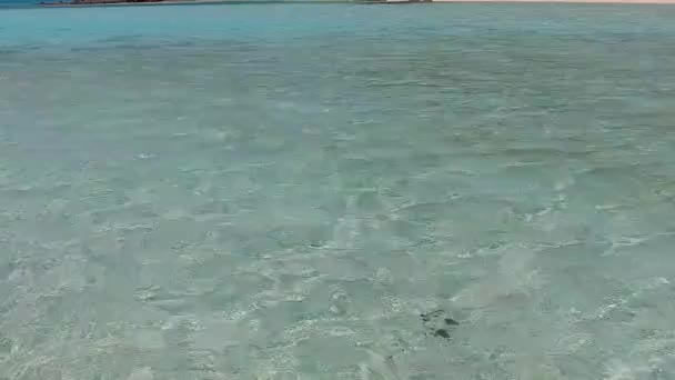 太陽の光の下で白い砂浜の背景を持つ青い緑のラグーンによるエキゾチックな海岸の冒険のロマンチックな海 — ストック動画