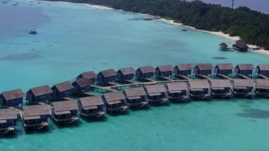 Turkuaz su ve tatil köyü yakınlarındaki beyaz kumlu arka planla mükemmel sahil seyahatinin geniş açılı dokusu