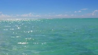 Egzotik tatil beldelerinin güneşli seyahatleri mavi deniz ve kumsalın yakınındaki beyaz kumsal arkaplanı kırar.