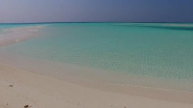 Lüks sahil şeridinde boş bir yolculuk sığ okyanus kıyısında tatil köyü yakınlarında beyaz kumlu bir arka plan.