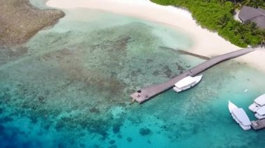 Turkuaz okyanus ve beyaz kumlu arka plandan gelen sakin sahil macerasının insansız hava aracı soyutlaması