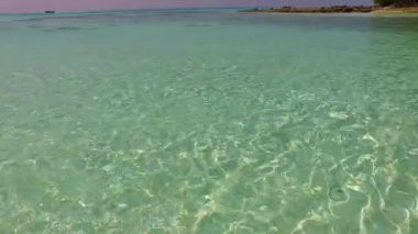 Turkuaz deniz ve dalgaların yakınındaki beyaz kumlu arka plandan oluşan egzotik ada plaj tatilinin ılık dokusu