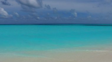 Güneş batmadan önce beyaz kumlu arka planlı sığ okyanus kıyısında egzotik turist plajı tatili.