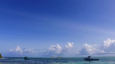 Lüks sahil seyahatinin saydam okyanus ve dalgaların yakınındaki beyaz kumlu arka plandaki uzay yolculuğunu kopyala