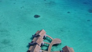 Cennetin boş doğası turistik plaj yaşam tarzı mavi sularda tatil köyü yakınlarında beyaz kumlu arka planda