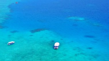 Günbatımından önce beyaz kumlu arka planda mavi yeşil deniz kıyısında tropikal adanın ılık deniz manzarası