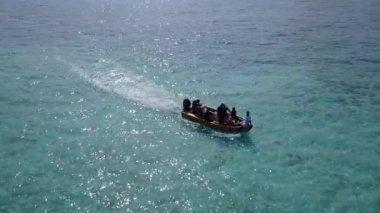 Turkuaz lagünün yanında egzotik körfez sahil saatinin geniş açılı deniz manzarası ve güneş doğduktan sonra beyaz kumlu arka plan.