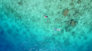 Mavi okyanus kıyısındaki tropikal sahil seyahatinin turizmini kapatın. Beyaz kumlu arka plan güneş ışığı altında.