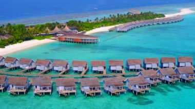 Mavi okyanus ve beyaz kumlu arka planda tropikal sahil yaşam tarzının insansız hava aracı yolculuğu