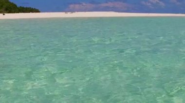 Mavi okyanus kıyısındaki tropikal sahil macerası ve kumsalın yakınındaki beyaz kum arka planının boş bir özeti.