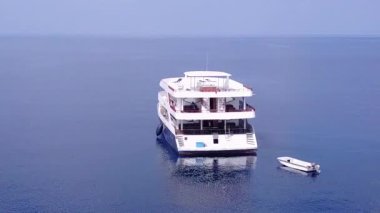 Cennet tatil beldesinin insansız hava aracı soyutlaması beyaz kumlu arka planlı mavi deniz kenarında tatil