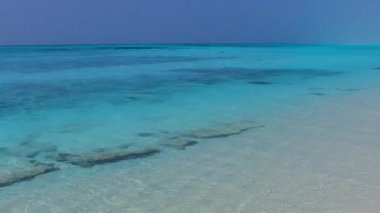 Aqua mavi denizi ve palmiyelerin yakınındaki beyaz kum arkaplanı yakınlarındaki turist plajı gezisi.