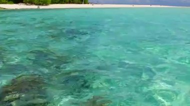 Mükemmel turistik sahil gezisi, beyaz kumlu arka planda, resifin yanında berrak bir göl kenarında.