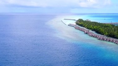 Dalgaların yakınındaki beyaz kum ve sığ sularla yapılan egzotik sahil yolculuğunun uzay manzarasını kopyala