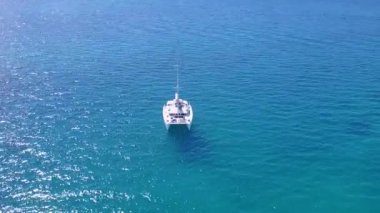 Mavi deniz kıyısında romantik bir deniz macerası ve kumsalın kenarında kumlu bir zemin.