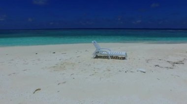 Deniz turistlerinin sahili temiz su ve palmiyelerin yakınındaki parlak kumlu zemin ile kaplıdır.